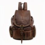 Un petit sac à dos vintage similicuir aux allures vintage. Ce sac a de multiples poches avant et deux poches à fermeture éclaire sur les côtés et une à l'arrière.