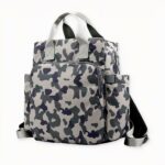 La conception du sac comprend une grande poche principale avec une fermeture à glissière, ainsi qu'une poche avant zippée et une poche arrière pour plus de rangement. Les bretelles sont réglables et confortables, ce qui permet aux parents de le porter facilement.