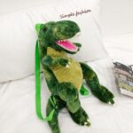 Sac à dos original dinosaure 3D vert dans un lit blanc