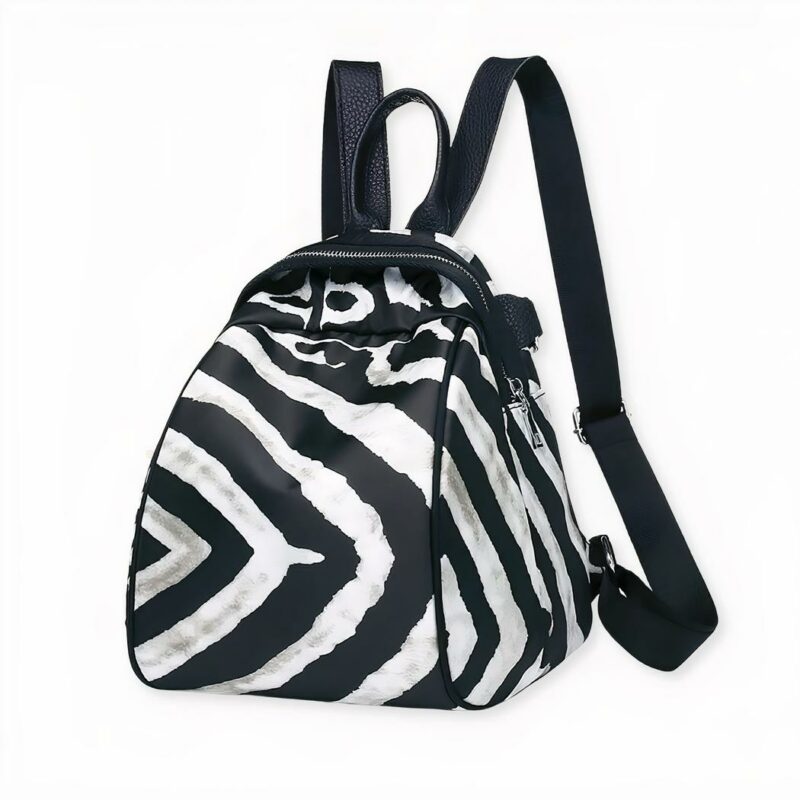 Petit sac à dos femme en tissu à motif zèbre sur fond gris clair.