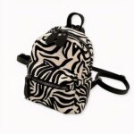 sac à dos femme motif zèbre en velours côtelé sur fond gris clair.