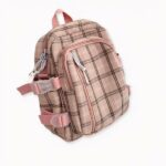 Sac à dos carreaux femme style preppy sur fond gris clair.