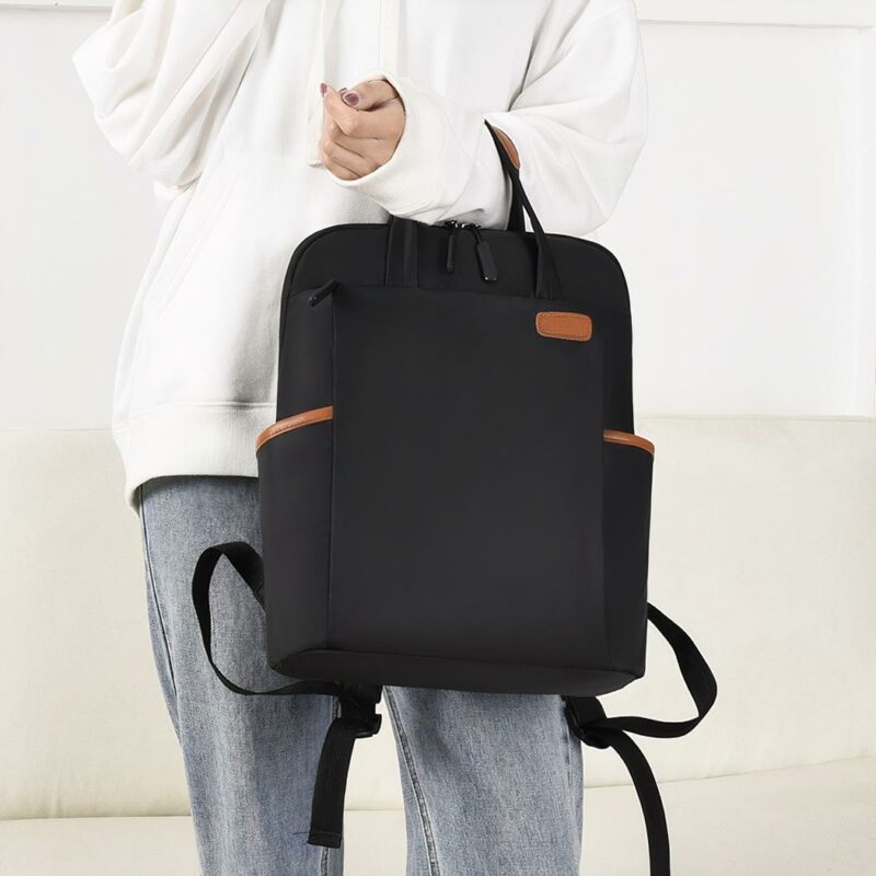 Sac à dos étanche pour femmes d'affaire noir avec un mannequin qui tient le sac