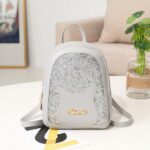Mini sac à dos à paillette pour fille gris avec un fond une table blanche avec un fond un canapé beige