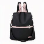 Sac à dos rose et noir waterproof en oxford sur fond gris clair.