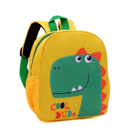Un sac à dos pour enfant jaune et vert représentent un dinosaure vert avec des petites écailles orange. Le sac est sur un fond blanc. Il a deux bretelles colorées à l'arrière.