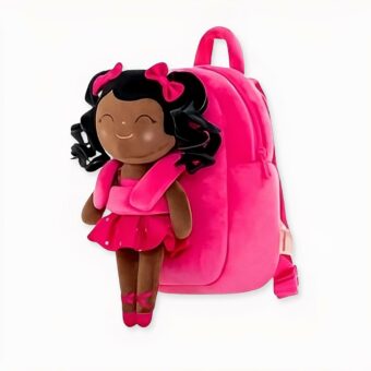 sac à dos de CP pour enfant , rose avec sur le devant une poupée en peluche d'une petite fille habillée en petite danseuse de ballet, c'est une jeune fille de couleur, elle est souriante et les yeux fermés.