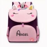 Sac à dos violet et rose pour enfant avec un design de licorne et le prénom Angel écrit, sur fond gris clair
