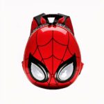 Photo d'un sac Spiderman, il est rouge et noir, et représente son visage avec des toiles d'araignée. Sa forme ressemble à un œuf, l'avant du sac est brillant, ses yeux sont blancs avec un contour noir. Il y a le logo Marvel en rouge en haut à gauche de l'image. Le fond de la photo est blanc.