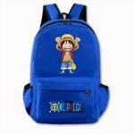 Photo d'un sac à dos One Piece bleu foncé. Le sac à dos dispose d'un motif à l'avant du personnage Luffy version manga, il est debout avec un t-shirt rouge et un short en jean. Il lève ses deux mains vers le haut, et son visage à l'air heureux. Sur la poche avant, il y a le logo One Piece avec un motif de tête de mort à chapeau et l'écriture en bleu. Le sac dispose également de poches latérales. Le fond de l'image est gris clair.