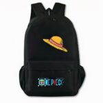 Photo d'un sac à dos noir, avec comme motif à l'avant un chapeau de paille entouré d'un ruban rouge. Sur la poche avant, il y a comme design le logo écrit One Piece en bleu avec une tête de mort à gauche. Le sac dispose également de deux poches latérales. Le fond de l'image est gris clair.