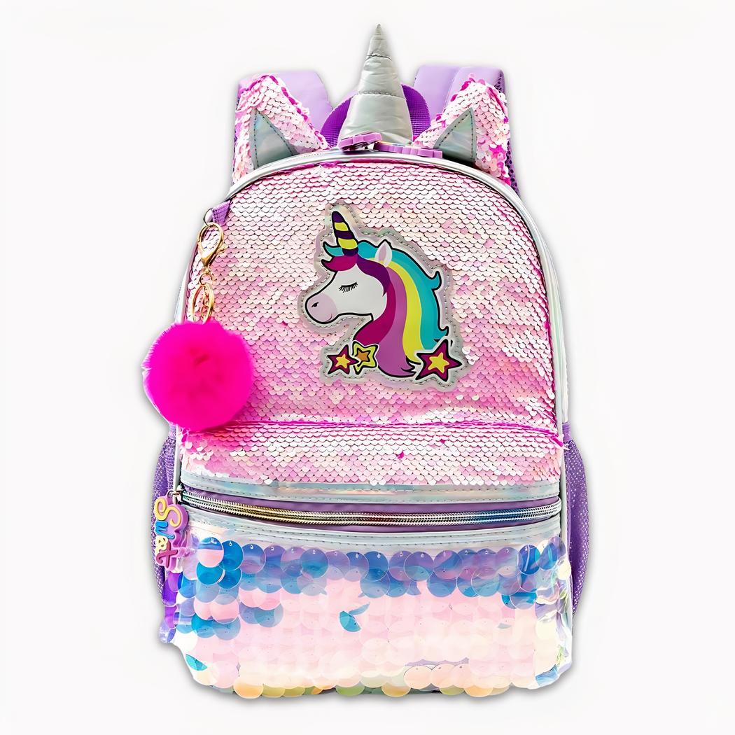Photo d'un sac à dos licorne avec un porte-clé en pompon rose. Sur l'avant du sac, il y a comme motif une licorne blanche avec une crinière arc-en-ciel. Le sac est rose aurora avec des sequins de petites tailles en haut et de grande taille en bas. Il y a une poche à l'avant et sur le dessus une corne et deux oreilles. Le fond de l'image est gris clair.