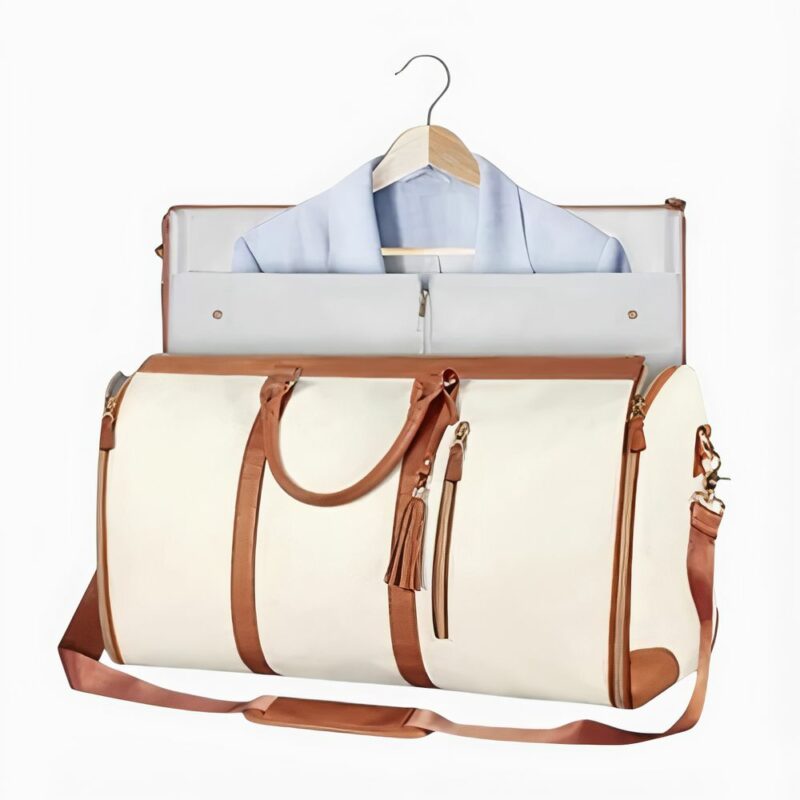 sac de voyage beige et détail marron, un peu ouvert sur le dessus avec une chemise qui en sort, sur fond blanc