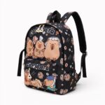 Un sac à dos capybara orné de cartes à jouer noir, avec des petits capybaras dessinés dessus et une poche avant zippée.