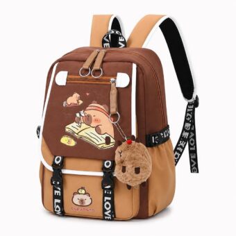 Un sac à dos capybara avec ours en pleine lecture marron et beige, avec une petite peluche accrochée, posé sur fond blanc.