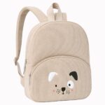 Un sac à dos maternelle en forme de chien beige avec un petit visage de chien brodé, posé sur fond blanc.