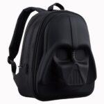 Un sac à dos Star Wars noir effet relief Dark Vador avec un visage en relief sombre, posé sur fond blanc.