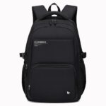Un sac à dos scolaire enfant ergonomique style minimaliste noir avec plusieurs poches zippées, bretelles rembourrées et dos renforcé, posé sur fond blanc.